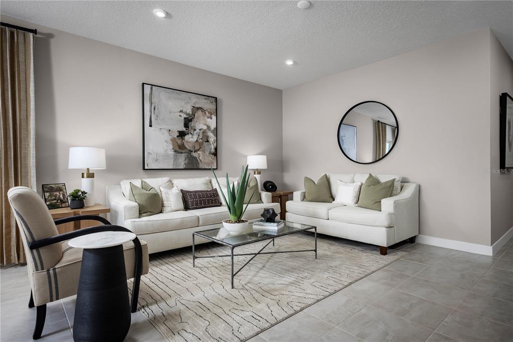 A living room features two white sofas, a glass coffee table, and a round mirror — 20462 LOU ANGELA LANE, LUTZ, FL