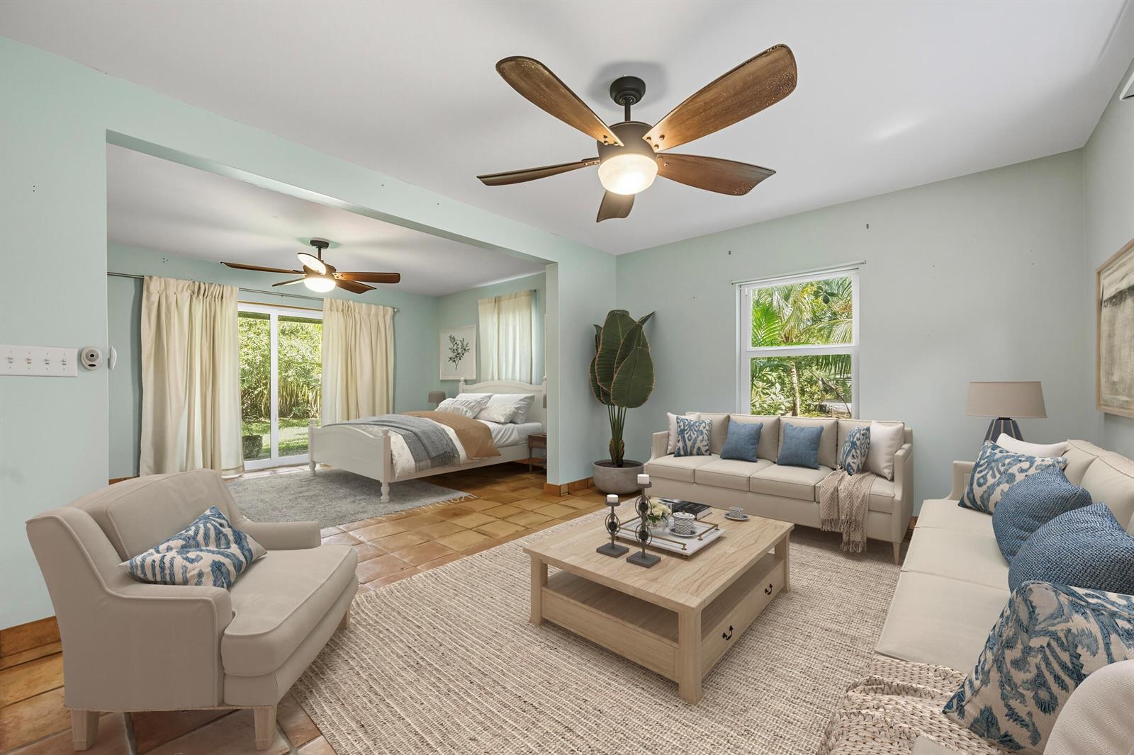 A combined living and bedroom space features light blue walls, tile floors, and ceiling fans — 1398 SW Palm City Road, Stuart FL 34994, STUART, FL