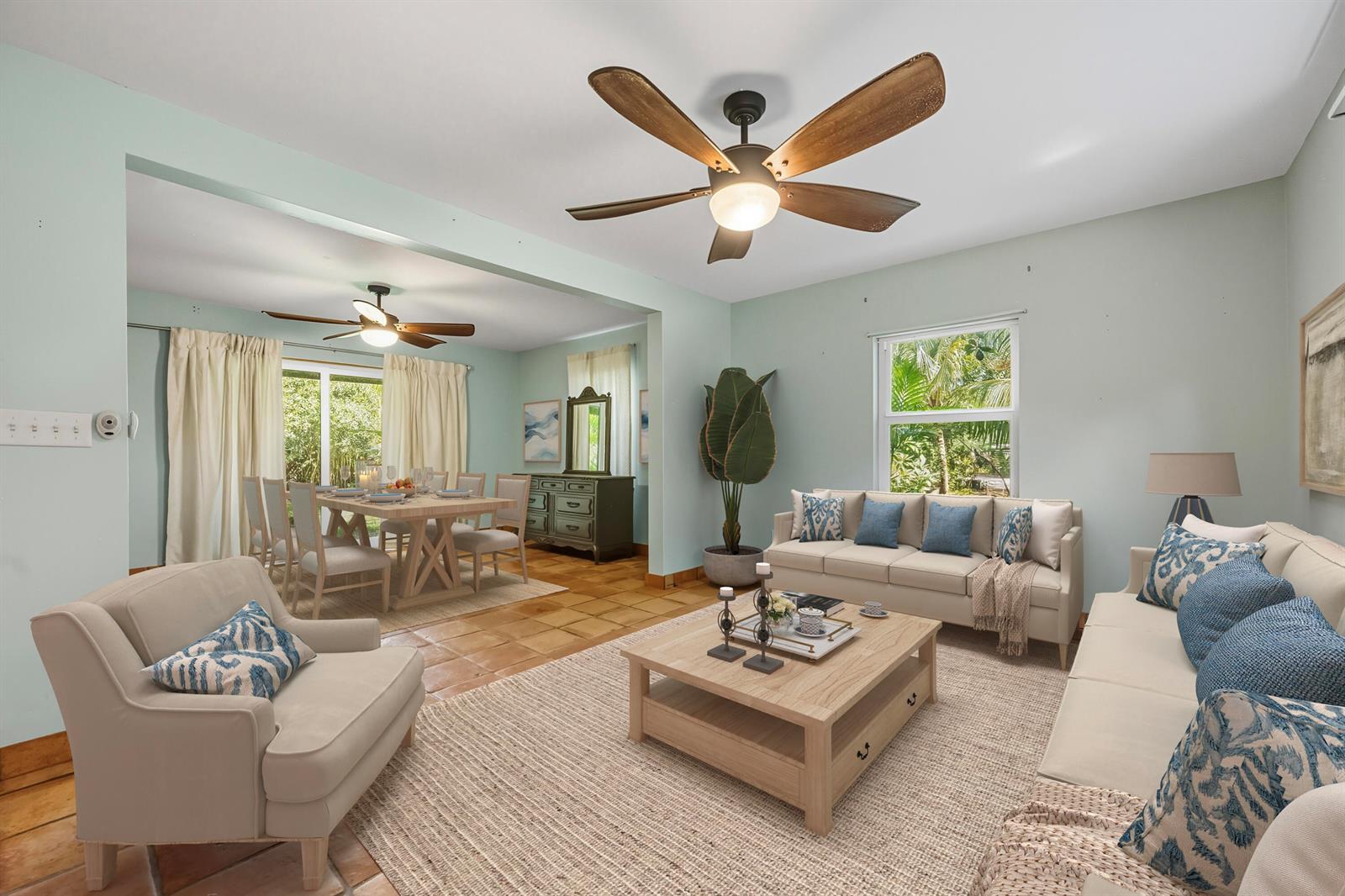 A living room and dining area feature light blue walls, tile floors, and ceiling fans — 1398 SW Palm City Road, Stuart FL 34994, STUART, FL