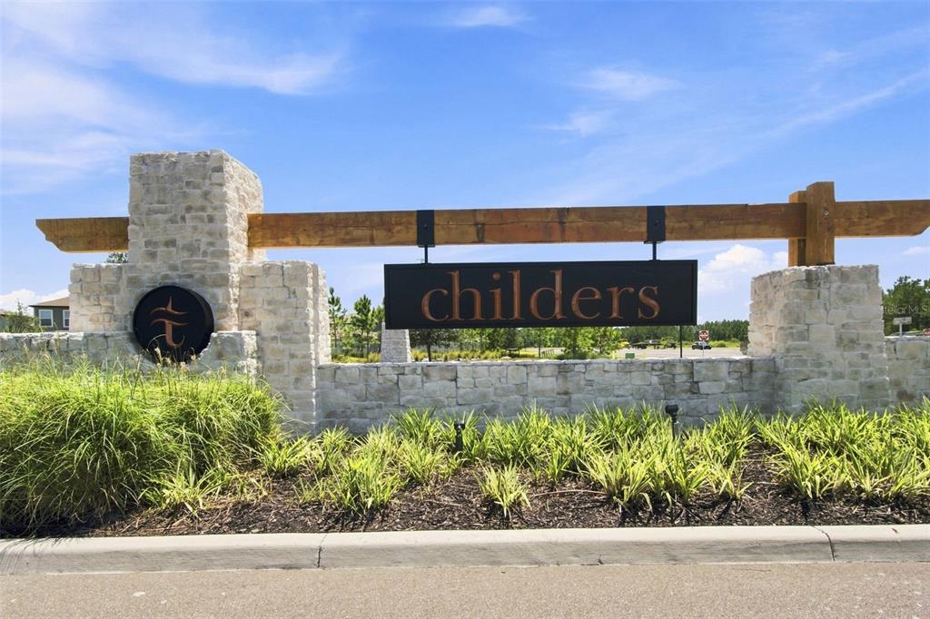 A stone monument sign with a wooden beam displays the name Childers in a neighborhood — 34701 RAINVILLE LOOP, ZEPHYRHILLS, FL