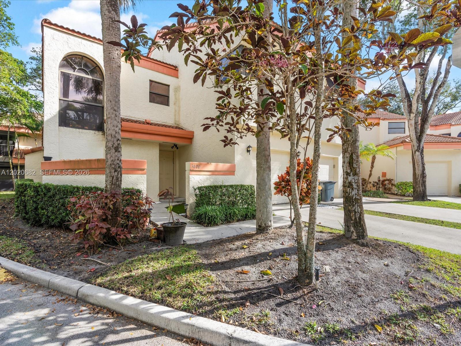 A two-story stucco townhouse with a tile roof and an attached garage — 3400 Emerald Oaks Dr # 801, Hollywood FL 33021, HOLLYWOOD, FL