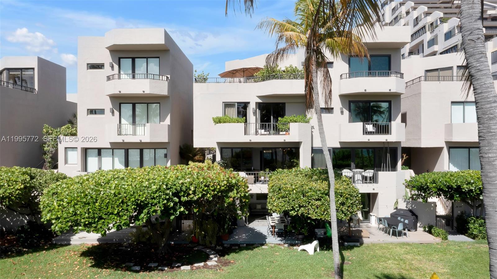 Exterior view of multi-story residential buildings with balconies and patios overlooking a grassy lawn — 201 Crandon Blvd # 175, Key Biscayne FL 33149, KEY BISCAYNE, FL