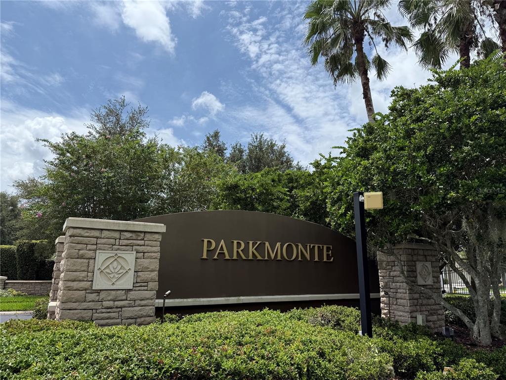 A stone monument sign with the name Parkmonte stands in front of lush green landscaping — 3806 WASHBURN PLACE, WESLEY CHAPEL, FL