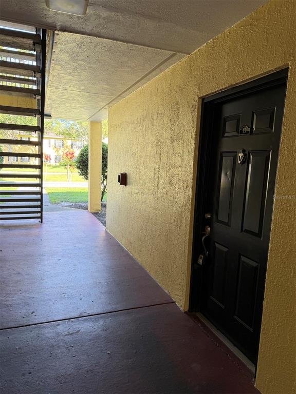 A black front door with a knocker is located on a covered outdoor walkway — 2019 DIXIE BELLE DRIVE UNIT 2019D, ORLANDO, FL