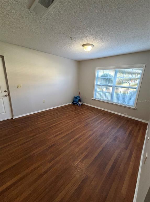 An empty room features wood-look flooring, light-colored walls, a ceiling light, and a window with blinds — 2019 DIXIE BELLE DRIVE UNIT 2019D, ORLANDO, FL
