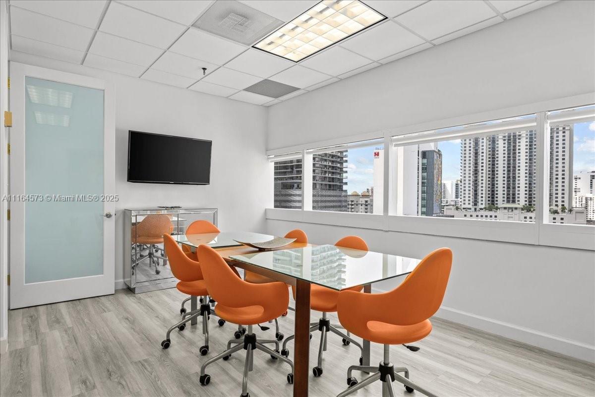 A conference room features a glass table, orange chairs, and a view of city buildings — 848 Brickell Ave, Miami FL 33131, MIAMI, FL