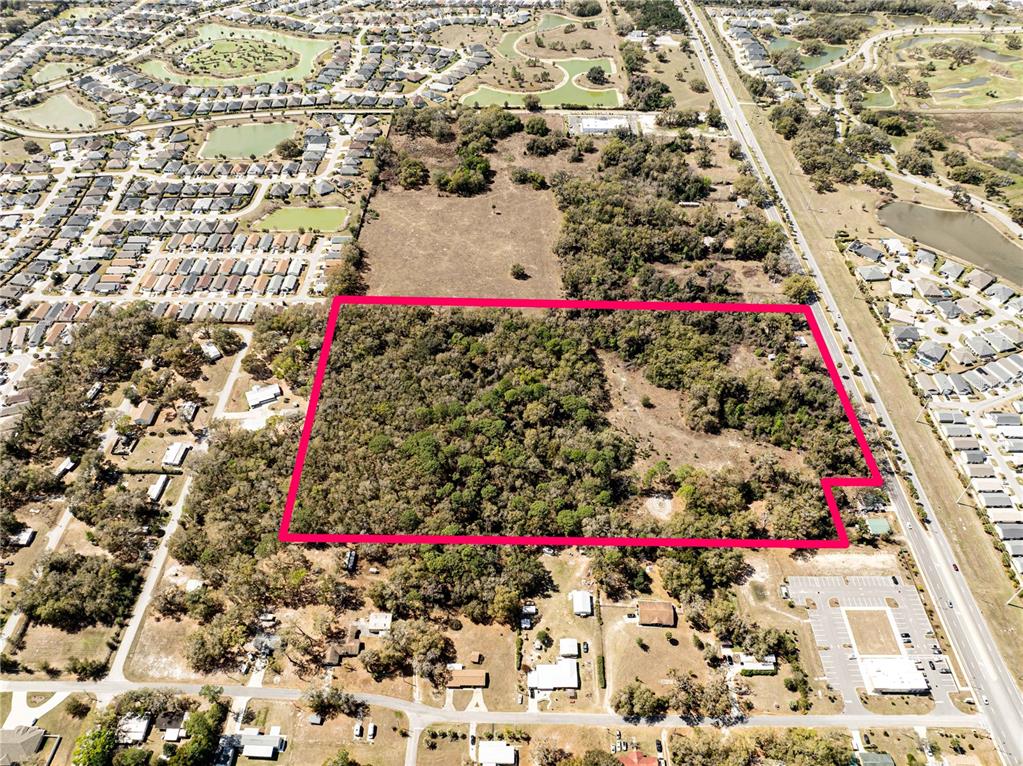 An aerial view shows a rectangular, wooded plot of land outlined in bright pink — 5245 WARM SPRINGS AVENUE, WILDWOOD, FL