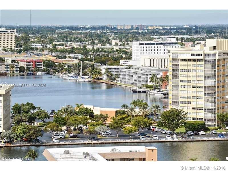An aerial view shows a waterway, residential buildings, and a parking lot with cars — 1904 S Ocean Dr # 1607, Hallandale Beach FL 33009, HALLANDALE BEACH, FL