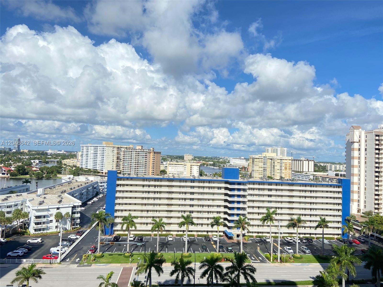 An elevated view shows a large apartment complex with blue accents and a parking lot — 1904 S Ocean Dr # 1607, Hallandale Beach FL 33009, HALLANDALE BEACH, FL