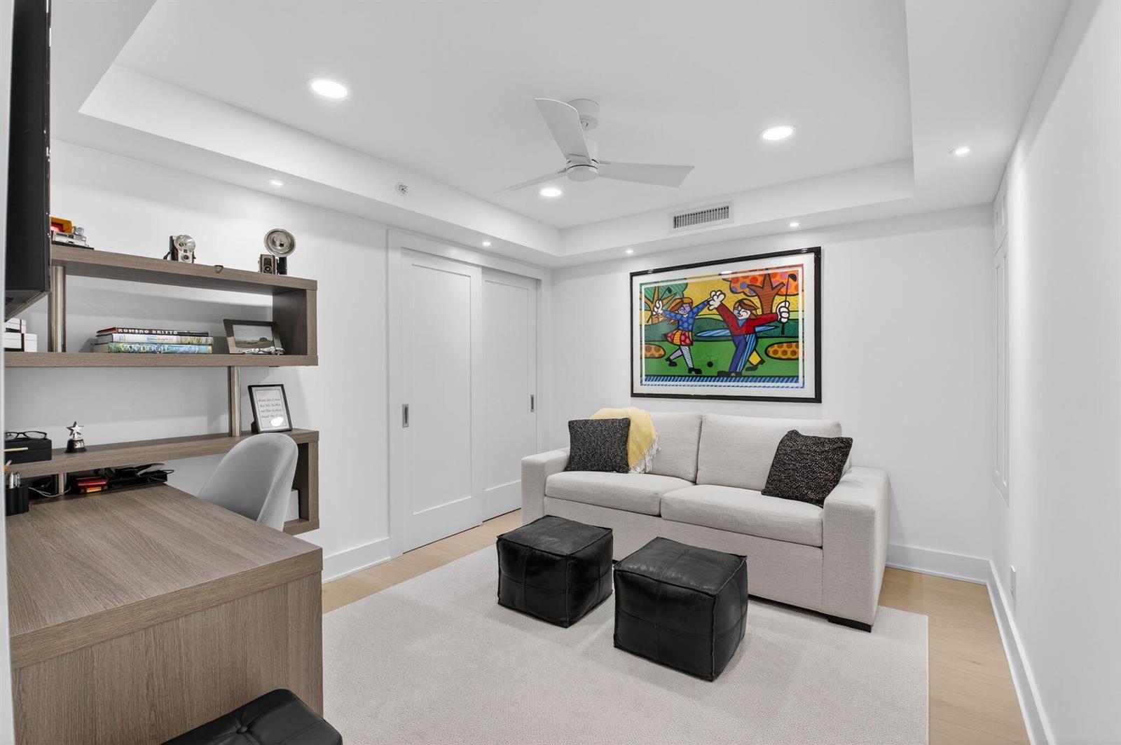 A modern home office with a desk, shelving, sofa, and two black leather ottomans — 3400 S Ocean Boulevard # 10m, Highland Beach FL 33487, HIGHLAND BEACH, FL