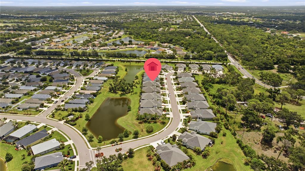 An aerial view shows a residential neighborhood with houses, ponds, and a red location marker — 4028 WILDGRASS PLACE, PARRISH, FL