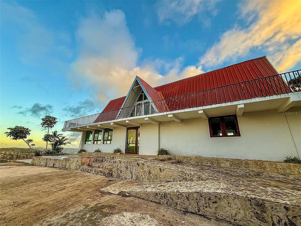 A white house with a red metal roof and a stone terrace exterior — PR 152 PR 773, BARRANQUITAS, PR