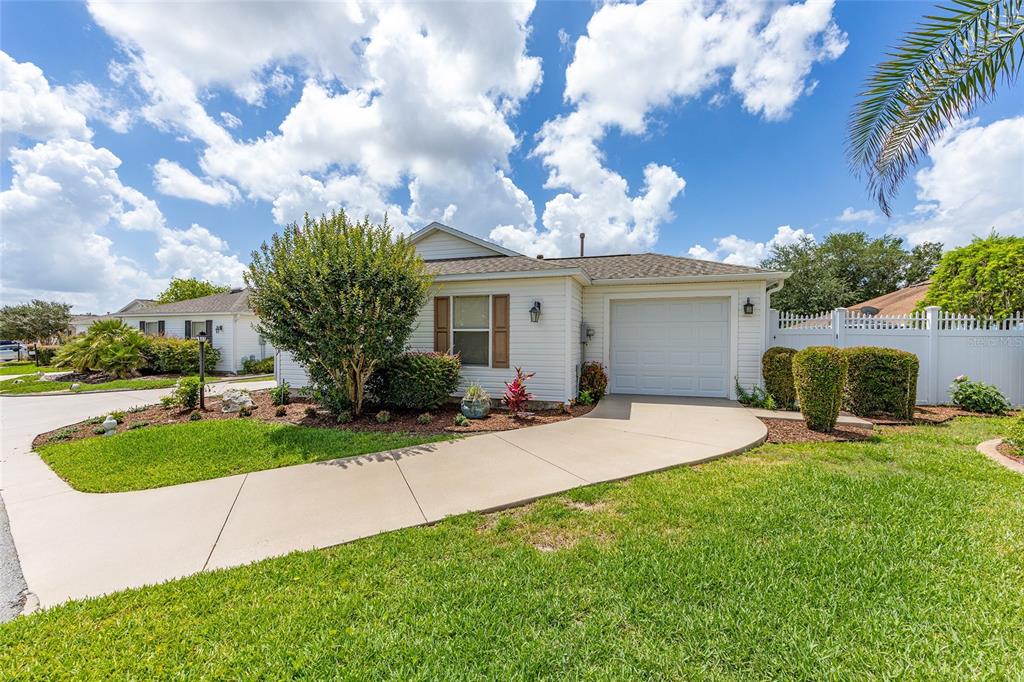 A single-story house with white siding, a one-car garage, and a curved concrete driveway — 1678 GOVAN PLACE, THE VILLAGES, FL