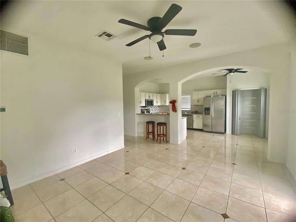 A tiled dining area opens into a kitchen with white cabinets and stainless steel appliances — 1690 BIG OAK LANE, KISSIMMEE, FL