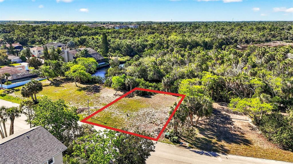 An aerial view shows a vacant, rectangular residential lot outlined in red near a waterway — 5804 SEABREEZE DRIVE, PORT RICHEY, FL