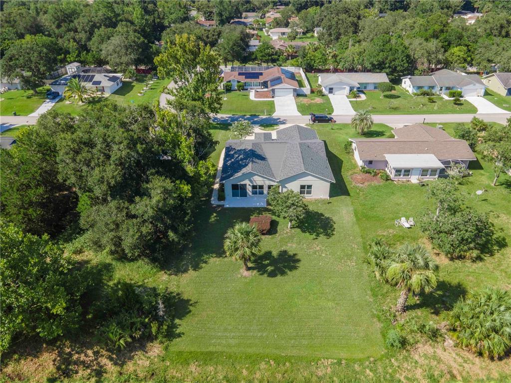 An aerial view shows a single-story house with a large backyard and surrounding neighborhood — 10 BLYTH PLACE, PALM COAST, FL