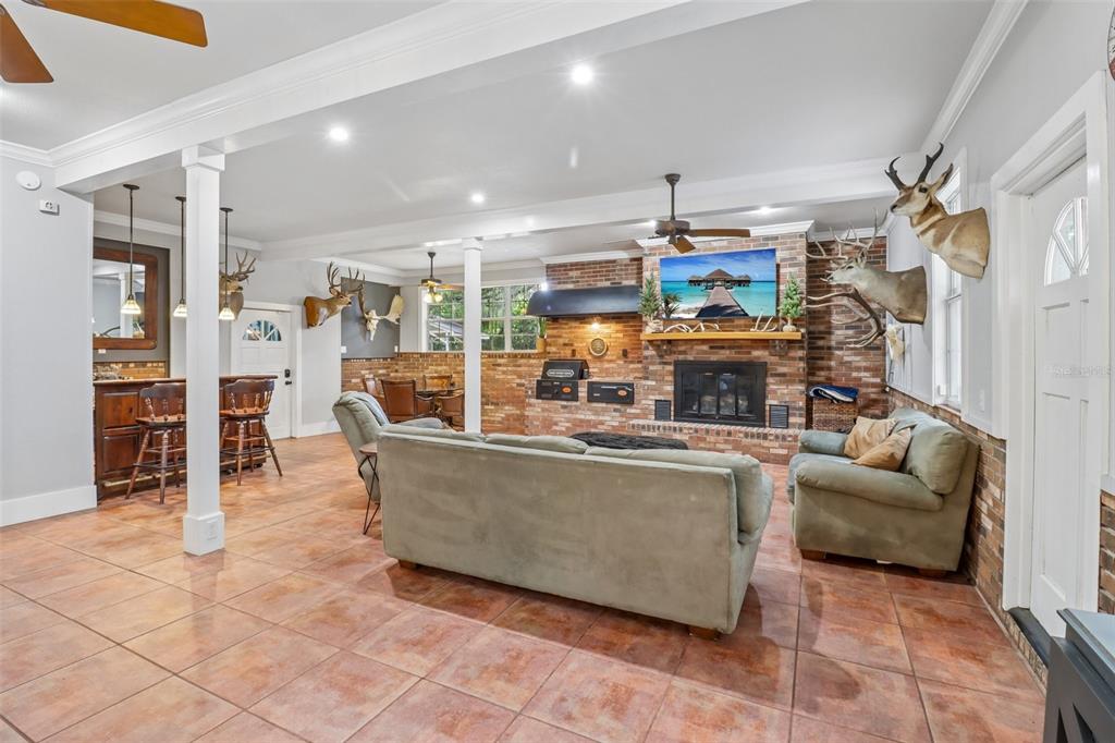 A living room features a brick fireplace, tile flooring, and several mounted animal heads — 649 GLENWAY DRIVE, SANFORD, FL