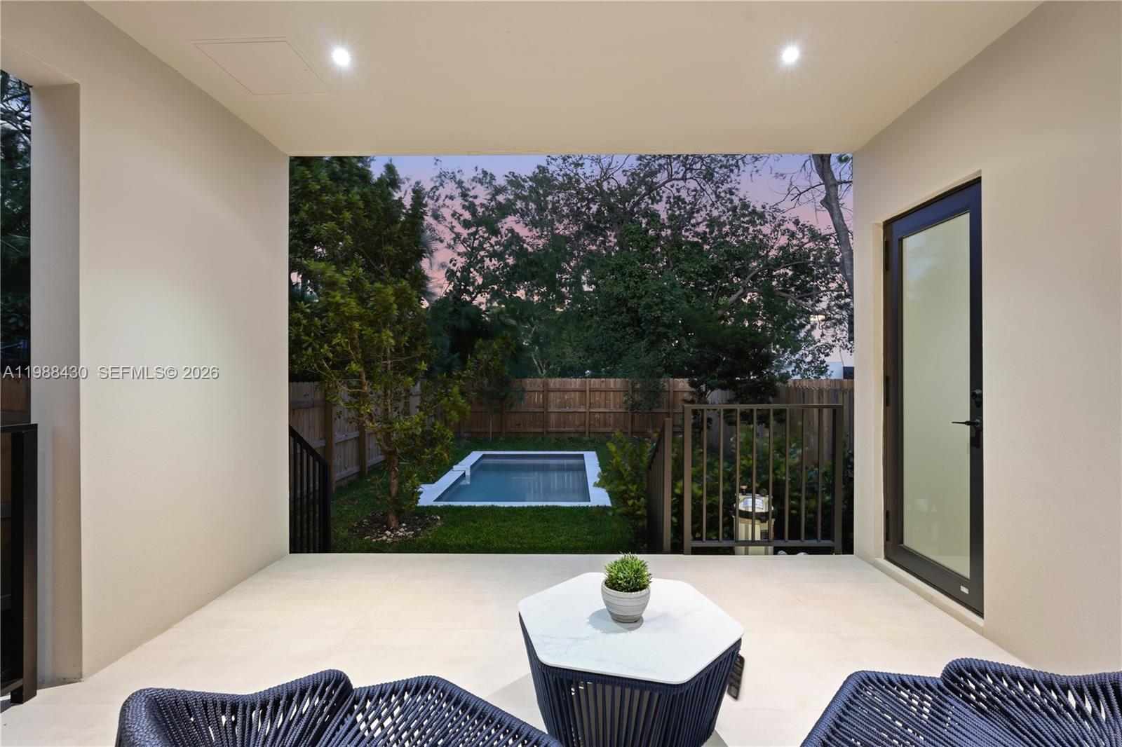 A covered patio overlooks a small backyard with a rectangular swimming pool and wooden fencing — 2925 SW 36th Ave, Miami FL 33133, MIAMI, FL