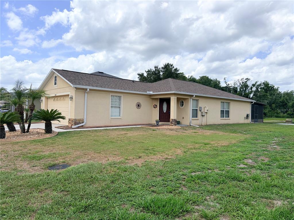A single-story house with a tan stucco exterior, a brown shingled roof, and a garage — 9847 EDMONTON DRIVE, LAND O LAKES, FL