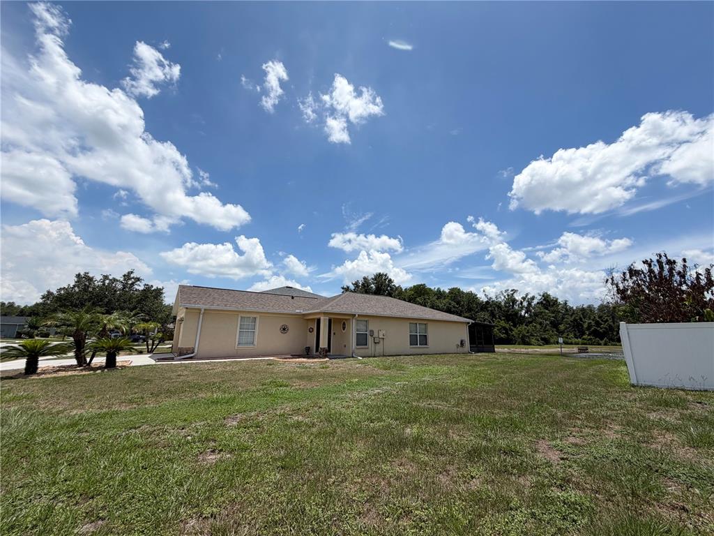 A single-story tan house with a shingled roof sits on a grassy lot — 9847 EDMONTON DRIVE, LAND O LAKES, FL