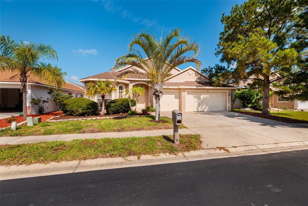 A kitchen with dark wood cabinets, granite countertops, stainless steel appliances, and tile flooring — 1805 WOOD BEND STREET, TARPON SPRINGS, FL