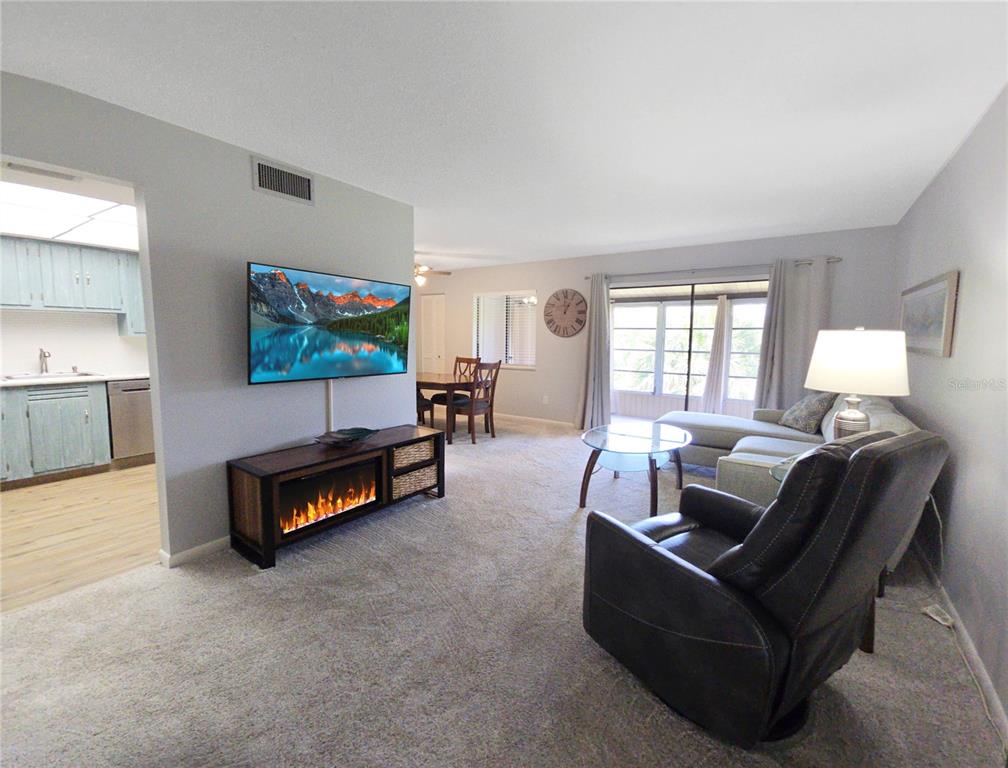 A living room features a fireplace media console, a television, and a leather recliner — 648 MIDWAY DRIVE UNIT B, OCALA, FL