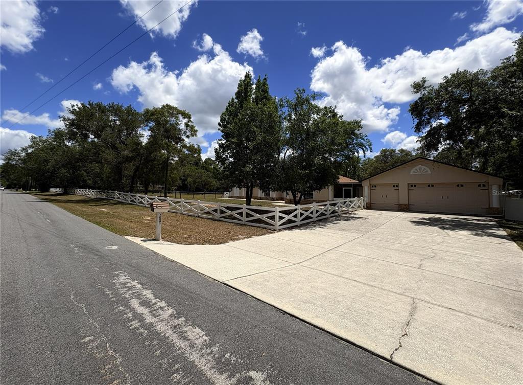 A single-story house with a two-car garage and a white fence along the front yard — 5085 BONE LANE, BROOKSVILLE, FL