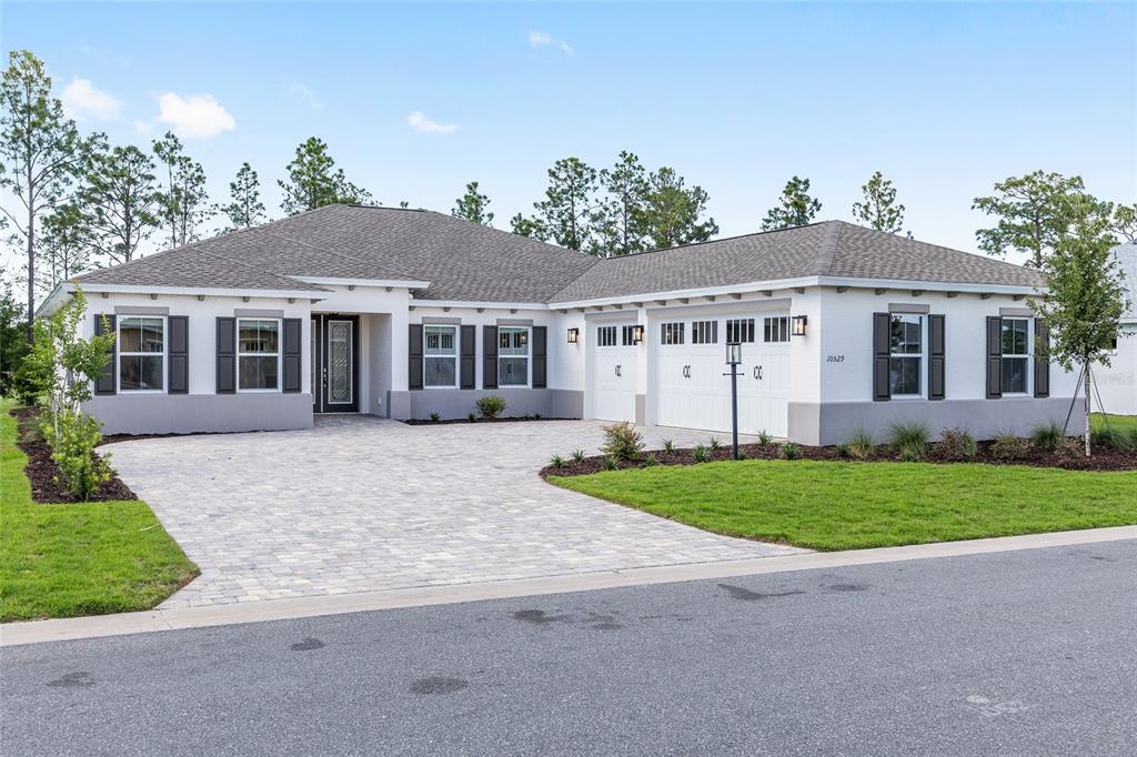 A single-story house with a white exterior, gray shutters, and a paved driveway — 10529 SW 96TH LANE ROAD, OCALA, FL