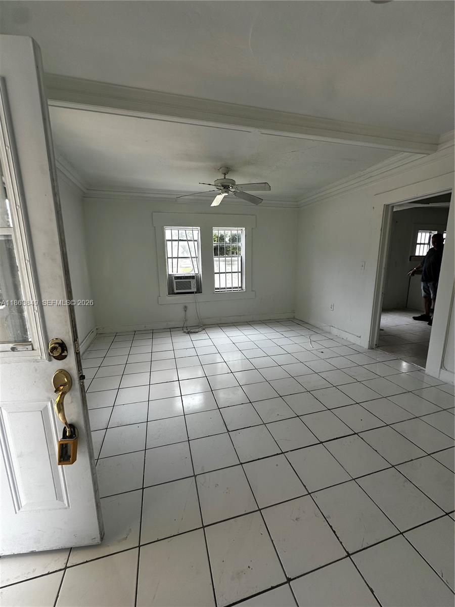 A room with white tiled floors, a ceiling fan, and a window air conditioning unit — 1925 NW 56th St, Miami FL 33142, MIAMI, FL