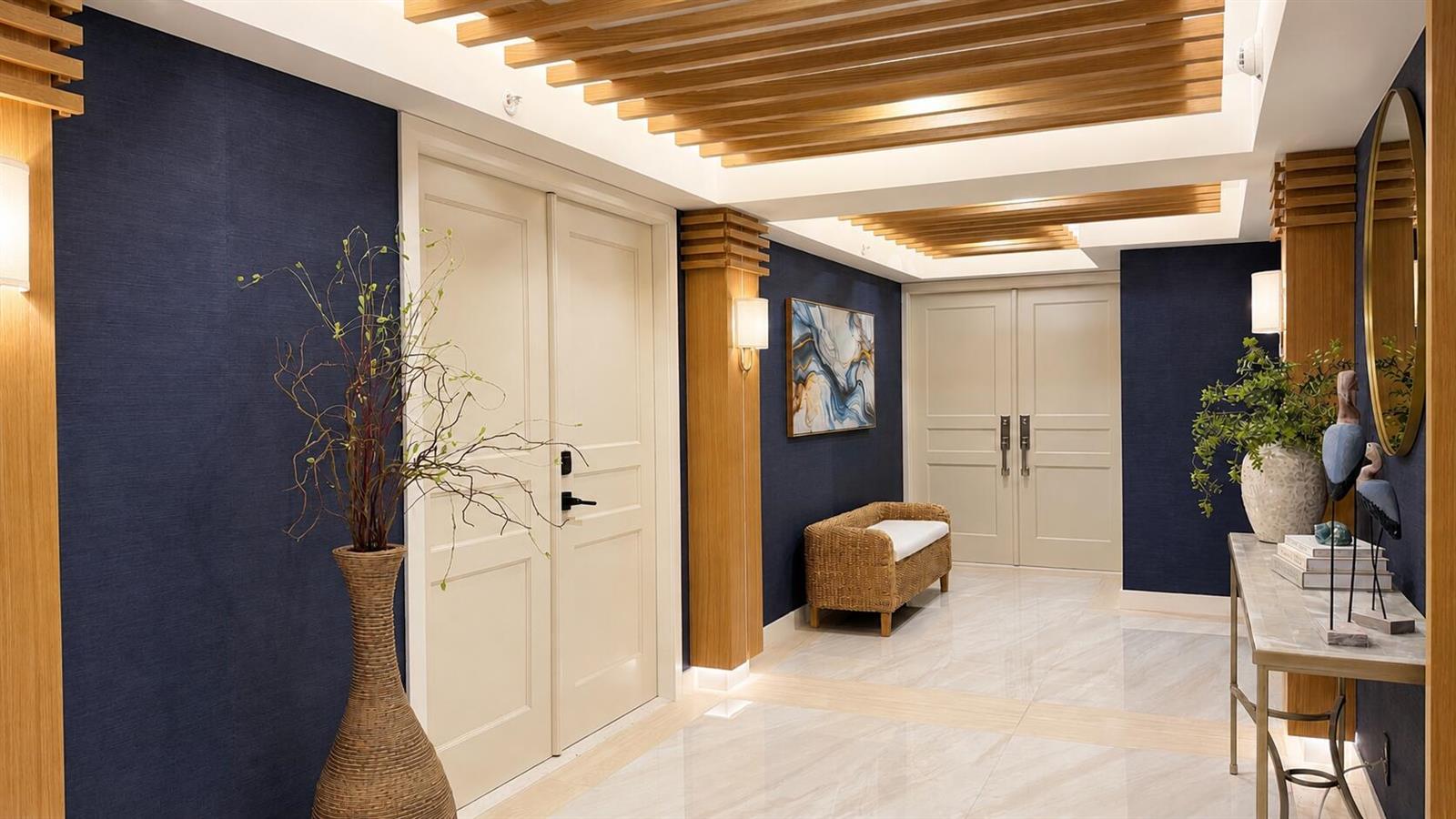 A hallway features dark blue walls, light wood ceiling slats, double doors, and marble flooring — 3000 S Ocean Boulevard # 1404, Boca Raton FL 33432, BOCA RATON, FL
