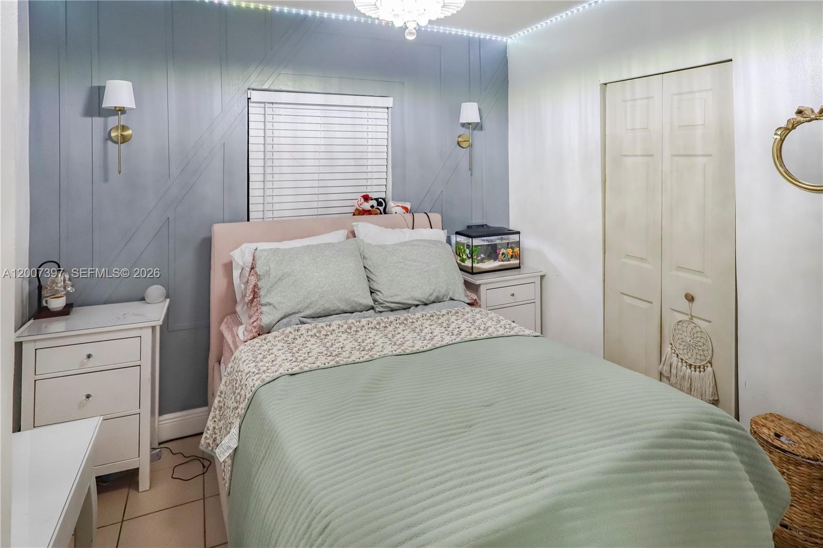 A bedroom features a blue accent wall with molding, a bed, and two white nightstands — 571 E 60th St, Hialeah FL 33013, HIALEAH, FL