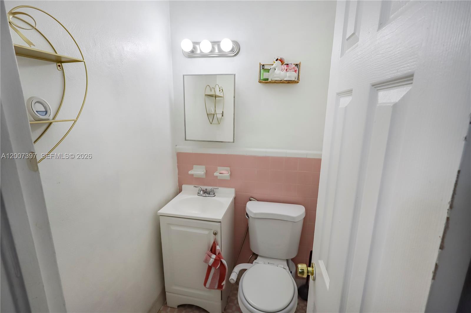 A small bathroom features a white vanity, a toilet with a bidet, and pink tiles — 571 E 60th St, Hialeah FL 33013, HIALEAH, FL