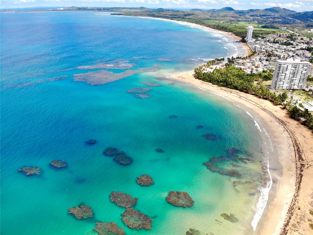 An aerial view of a sandy beach with coral reefs in turquoise coastal waters — 144 PLAZA VIRGEN GORDA, LUQUILLO, PR
