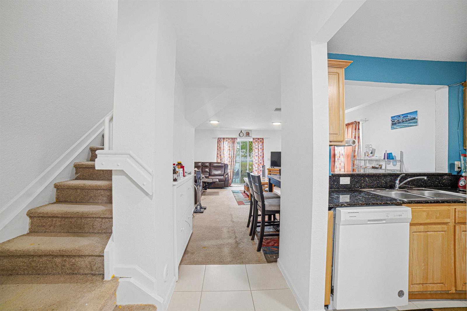 A view from a tiled entryway looking toward a carpeted living area and kitchen — 6631 Winfield Boulevard # 6, Margate FL 33063, MARGATE, FL