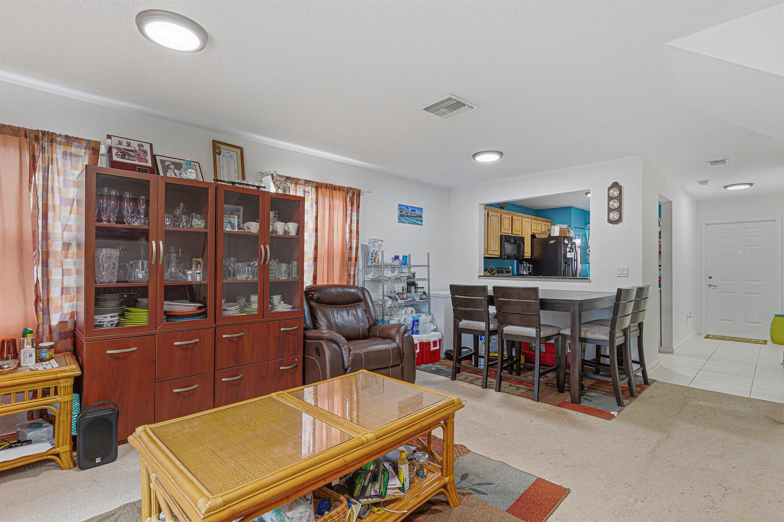 A living and dining area features a wooden hutch, a coffee table, and a pass-through window — 6631 Winfield Boulevard # 6, Margate FL 33063, MARGATE, FL