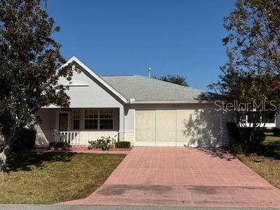 A single-story house with a light-colored exterior, a tiled driveway, and a two-car garage — 9759 SW 97TH LANE, OCALA, FL