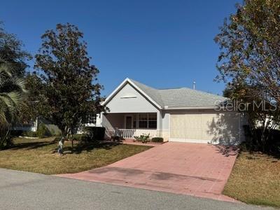 A single-story house with a light-colored exterior, a gabled roof, and a red paved driveway — 9759 SW 97TH LANE, OCALA, FL