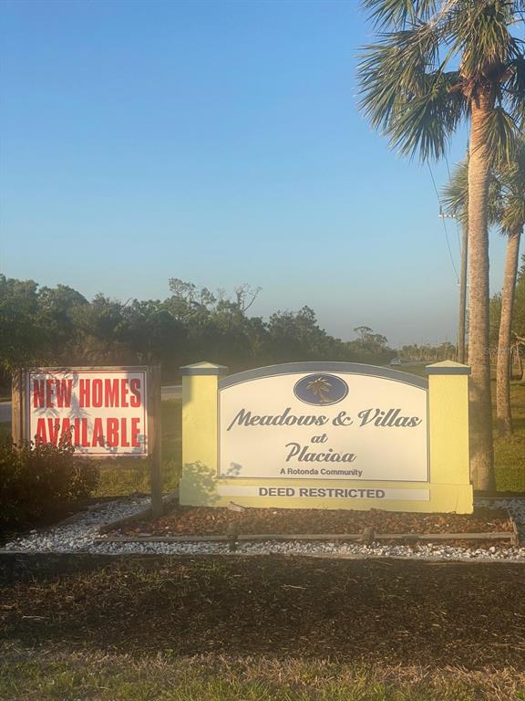 A sign for the Meadows and Villas at Placioa community stands near palm trees — 14420 BURBANK PLACE, PLACIDA, FL
