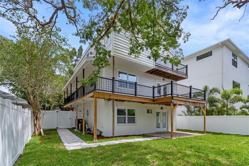A two-story house with a large wooden deck, white siding, and a fenced backyard — 3232 W OAKELLAR AVENUE, TAMPA, FL