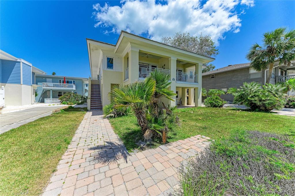A two-story yellow house with a covered porch, exterior stairs, and a brick walkway — 101 PALM AVENUE UNIT 2, ANNA MARIA, FL
