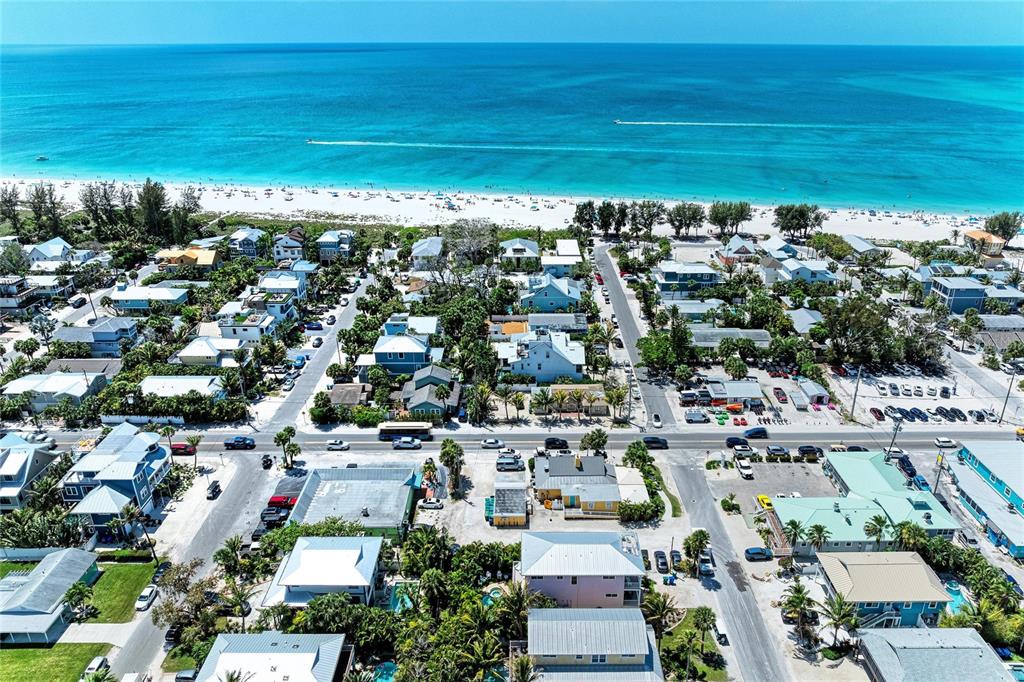 An aerial view shows a coastal town with houses, streets, and a sandy beach — 101 PALM AVENUE UNIT 2, ANNA MARIA, FL