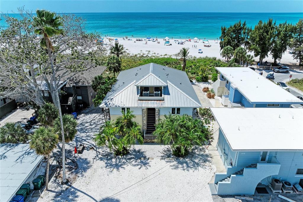 An aerial view of a coastal house with a metal roof near a sandy beach — 101 PALM AVENUE UNIT 2, ANNA MARIA, FL