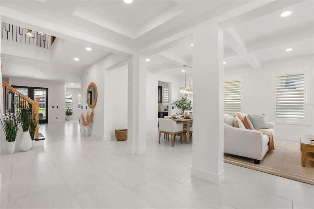 A bright, open-concept interior features white tile floors, a dining area, and a living room — 11716 SHELTERING PINE DRIVE, ORLANDO, FL