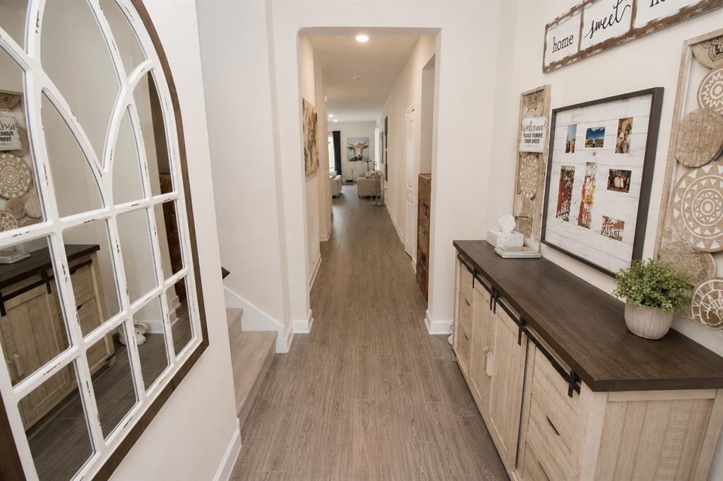A bright entryway features wood-look flooring, a console table, and a large arched wall mirror — 11620 SATIRE STREET, ORLANDO, FL