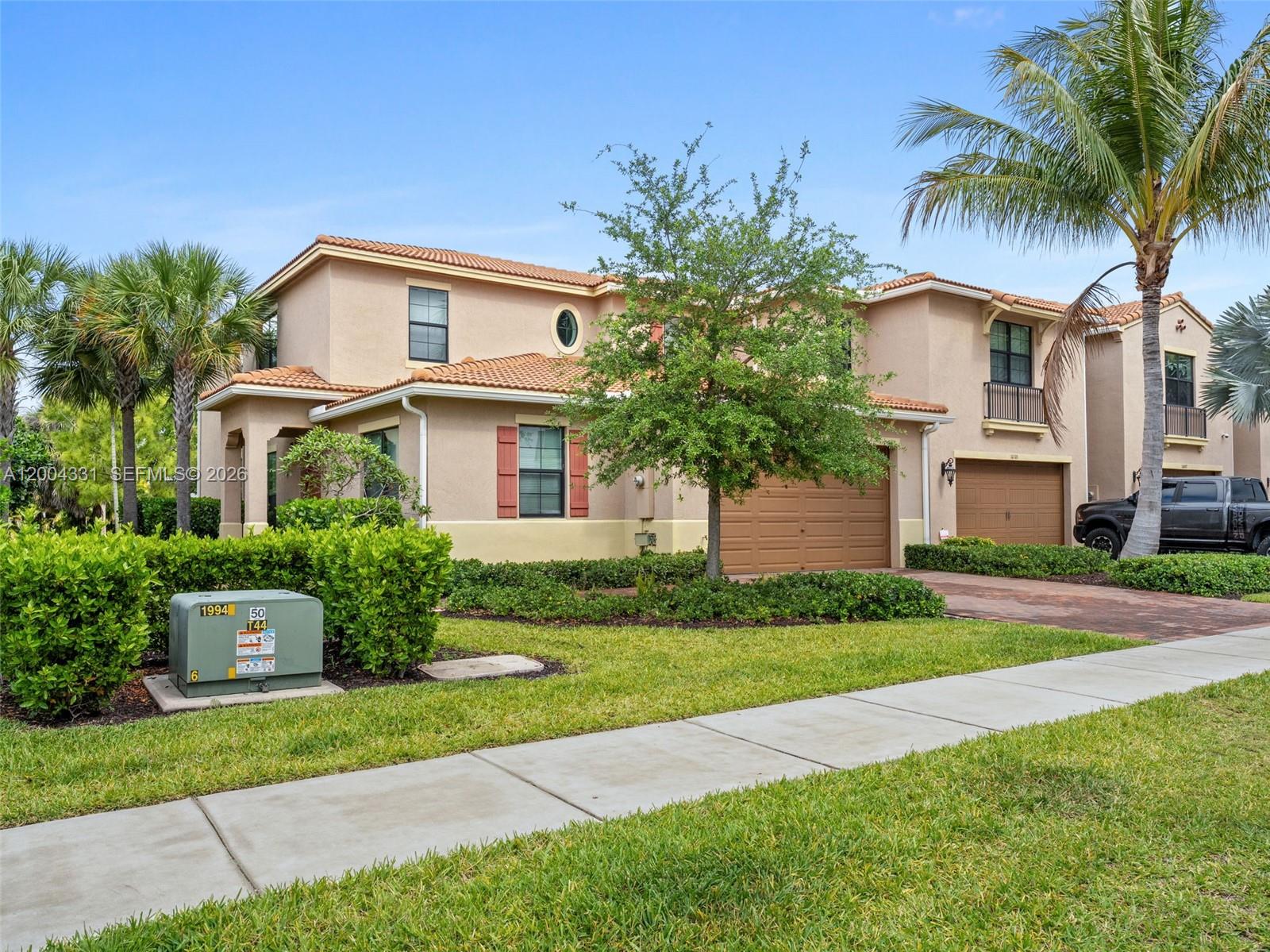 A two-story stucco house with a tile roof, two garages, and a front lawn — 10105 Brickhill Dr, Boca Raton FL 33428, BOCA RATON, FL
