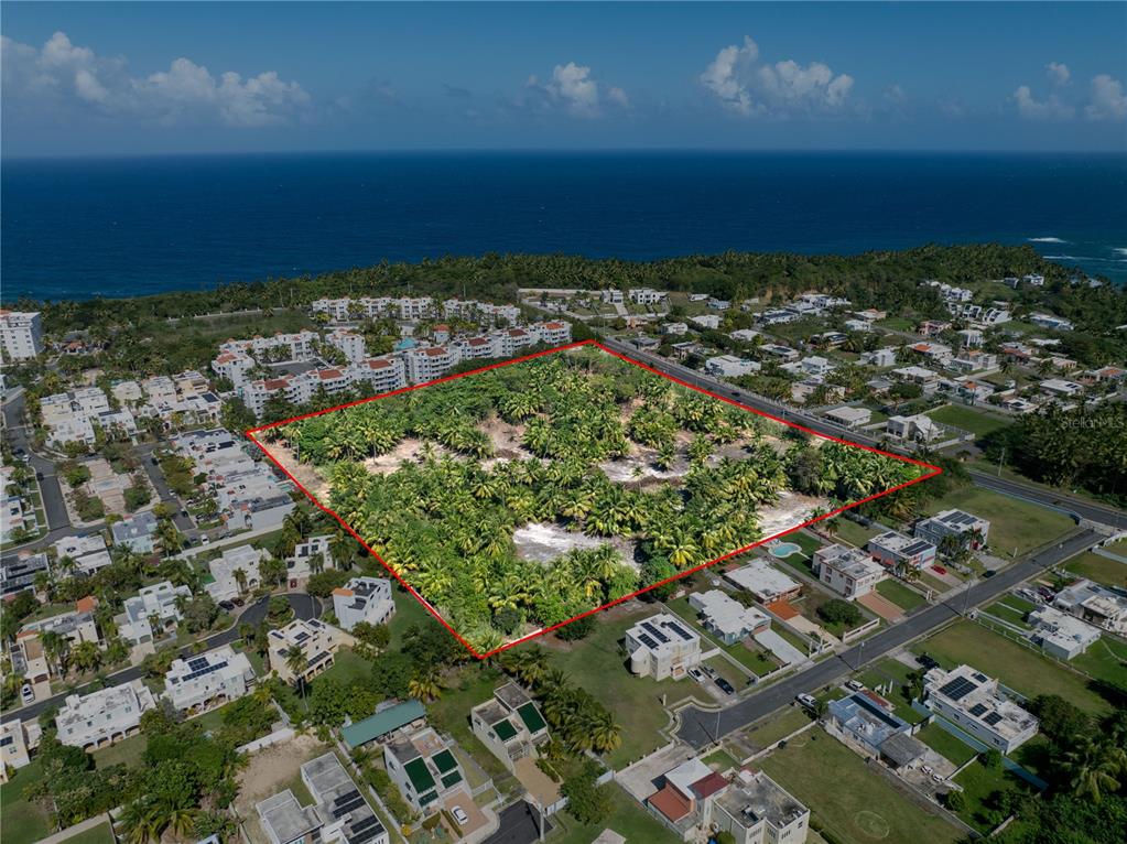 An aerial view shows a large, undeveloped rectangular plot of land surrounded by residential buildings — Kilometer 1.4 State Road SABANA WARD, VEGA ALTA, PR