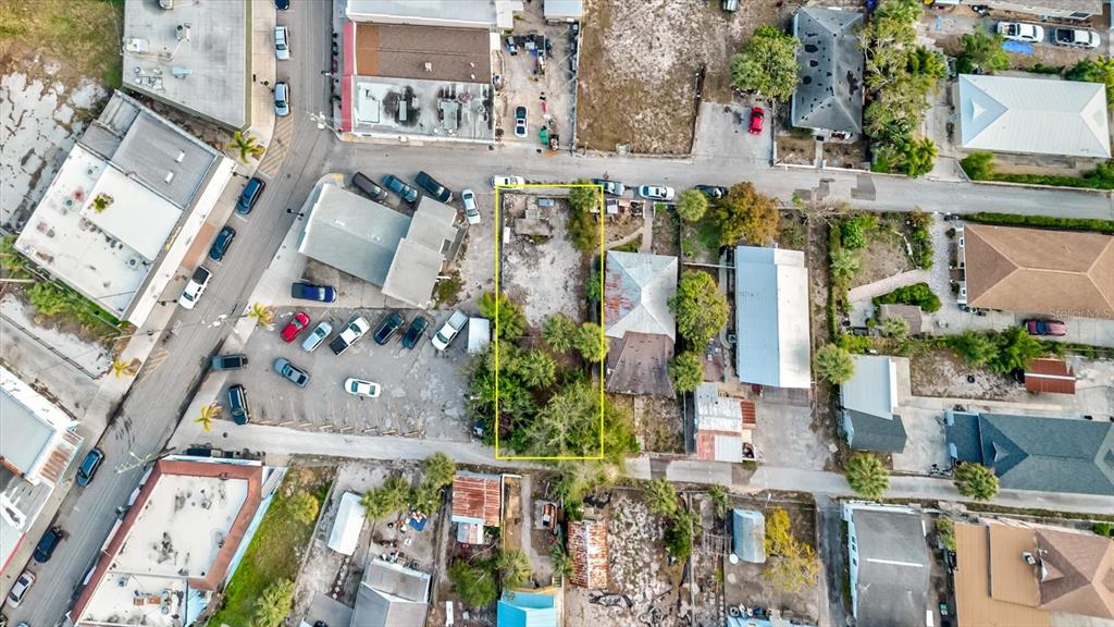 This aerial view shows a vacant, rectangular lot outlined in yellow within a residential neighborhood — ATHENS STREET, TARPON SPRINGS, FL