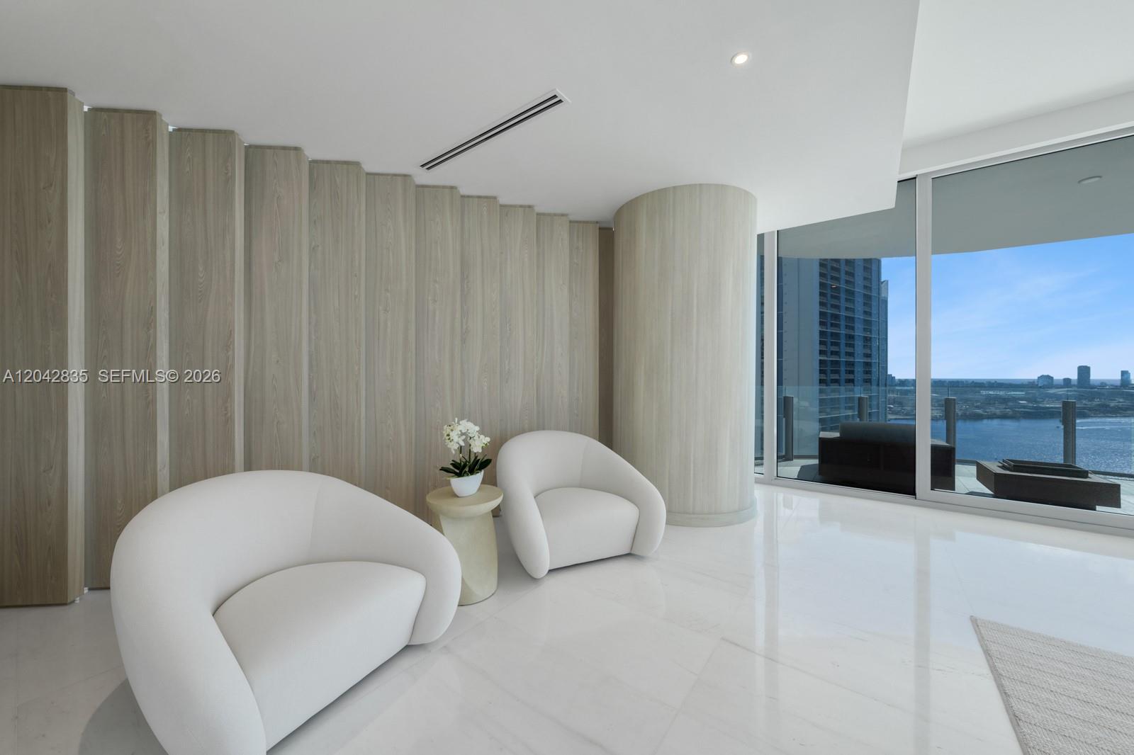 Two white armchairs sit on a marble floor before a curved wood-paneled wall — 300 Biscayne Boulevard Way # 2701, Miami FL 33131, MIAMI, FL