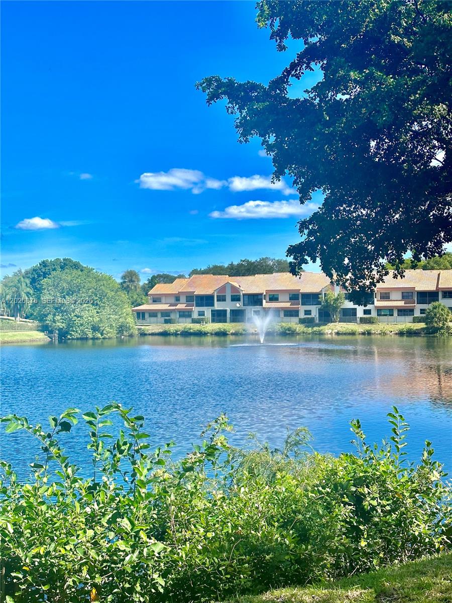 A view of a lake with a fountain in front of a multi-story apartment building — 3176 Arbor Ln # 2506, Hollywood FL 33021, HOLLYWOOD, FL