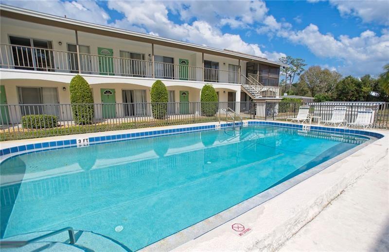 A two-story apartment building with a swimming pool in the foreground — 4035 S SCHOOL AVENUE UNIT B10, SARASOTA, FL